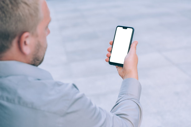 模拟技术。商人拿着一个智能手机在他的手近距离。图片下载