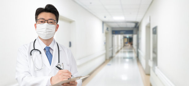 在医院里，一个亚洲男医生拿着一张医疗图表。素材图片