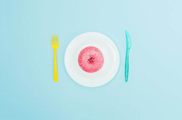 亮粉色的甜甜圈，蓝色的盘子和浅蓝色的背景。图片下载