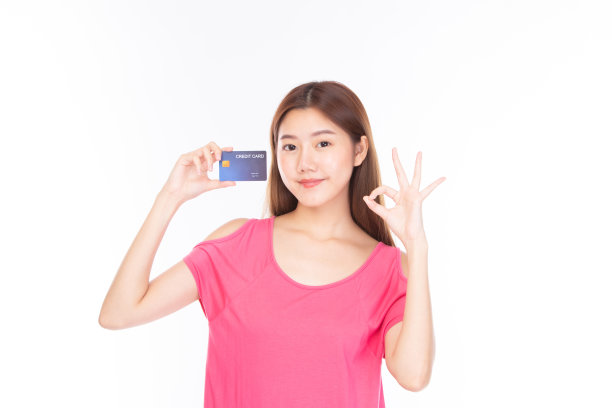 肖像亚洲年轻女孩快乐和微笑购物网上概念。迷人美丽的亚洲年轻女子显示信用卡购物网上，付款孤立在白色背景与拷贝空间。图片下载