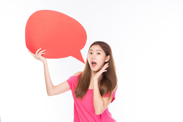 迷人的美丽的年轻亚洲女人微笑和兴奋抱着空的讲话气泡孤立在白色的背景。图片下载