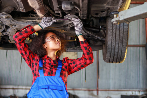 女汽车修理工在修理厂工作。素材图片