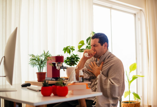 在家工作的男人，咳嗽和感觉不舒服图片下载