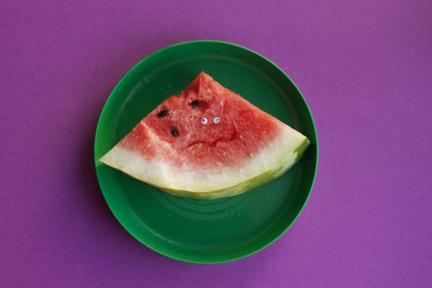 切片的眼睛西瓜躺在一个绿色的盘子里图片下载