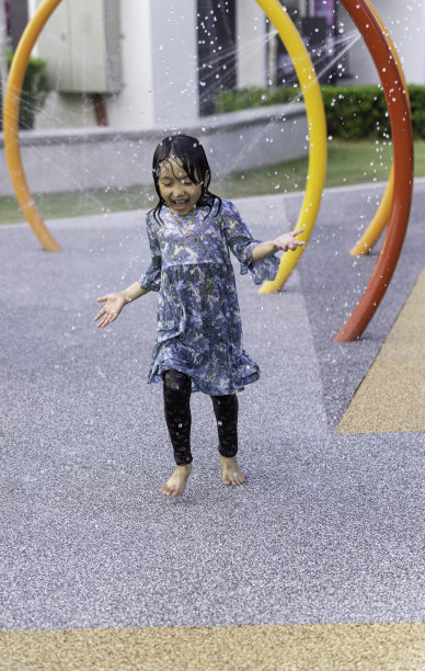 小女孩玩花园洒水器库存照片图片下载