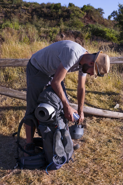 年轻的西班牙男性穿着运动服检查他的背包图片下载