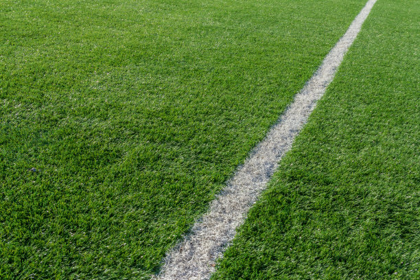 球场上绿草白边线。人造草皮足球场。人造绿草纹理。露天体育场中的人造足球场图片下载