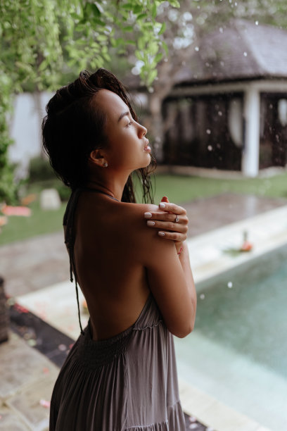 女孩在巴厘岛豪华别墅的游泳池里放松。图片下载