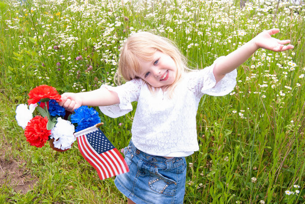 金发小女孩拿着美国国旗在战场上图片下载