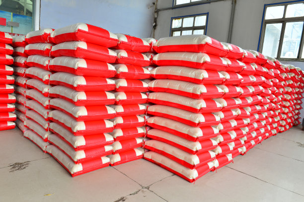 大仓库里有许多排装着货物的白色塑料袋图片下载