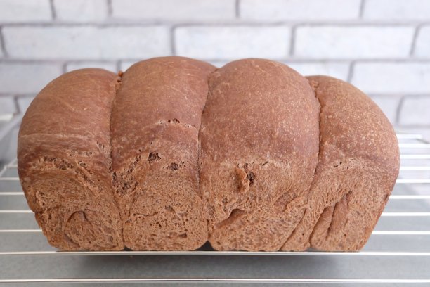 选择焦点自制的巧克力面包在食物格栅和厨房白砖墙的背景图片下载