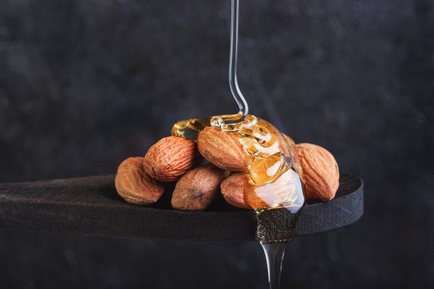 把杏仁放在木勺里，倒上蜂蜜图片下载