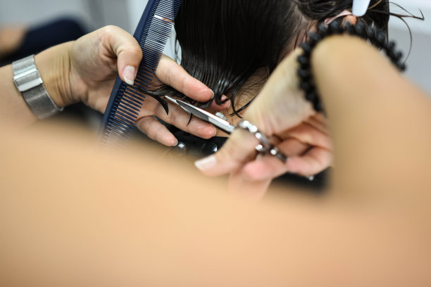 剪短的照片，一个女性客户接受理发在美容院。健康头发小贴士概念图片下载