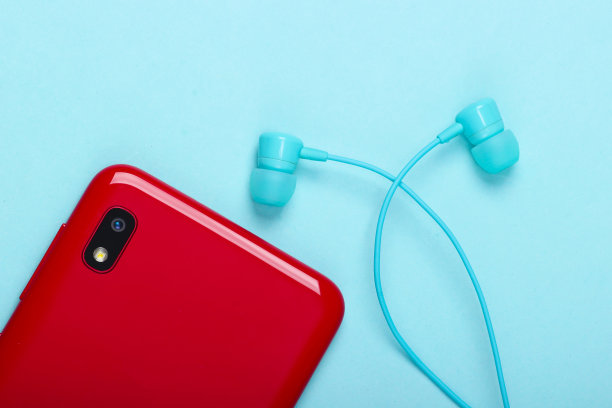 蓝色背景的真空耳机智能手机。俯视图图片下载