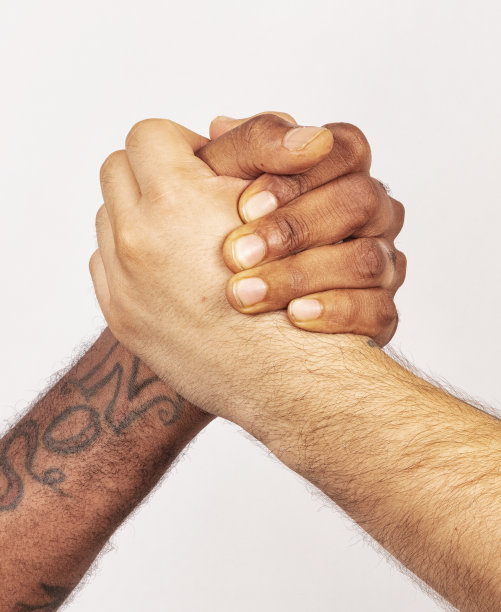 白人和黑人在白人背景前互相握手。图片下载