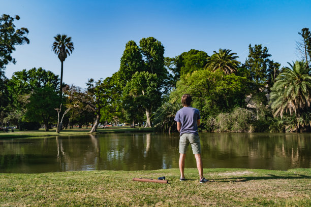少年在公园的湖里钓鱼图片下载