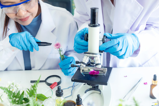 亚洲女性和团队科学实验室研究天然替代草药和鲜花精油的新产品，用显微镜护肤。健康实验室图片下载