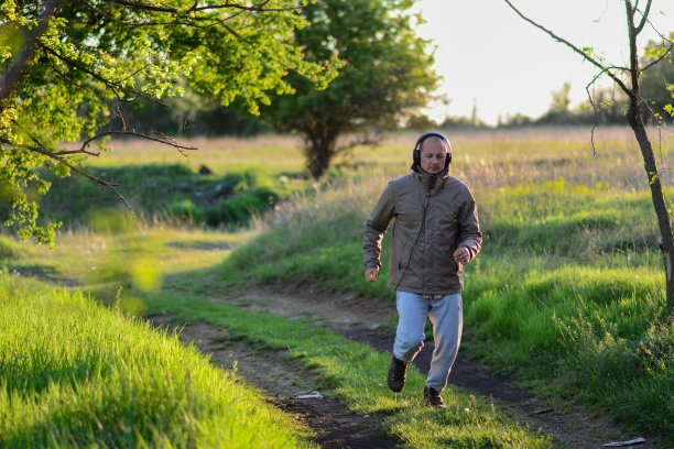 跑步是保持健康的最好方法之一。一个中年男人英俊的男人在户外奔跑图片下载