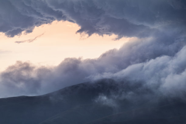 美丽的日落景观。近距离的山景在巨大的戏剧性的云日落。图片下载