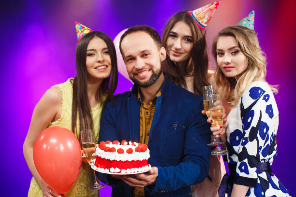 生日快乐。一群微笑的朋友聚在一起吃蛋糕。图片下载