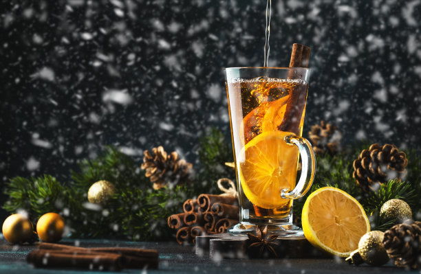 圣诞或新年冬季热饮，辛辣烈酒鸡尾酒，潘趣酒或热葡萄酒与茶，柠檬，朗姆酒，肉桂，雪下大茴香图片下载