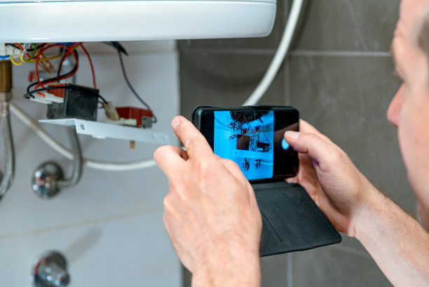 一名男子从家中浴室里取出一台旧热水器修理电热锅炉图片下载