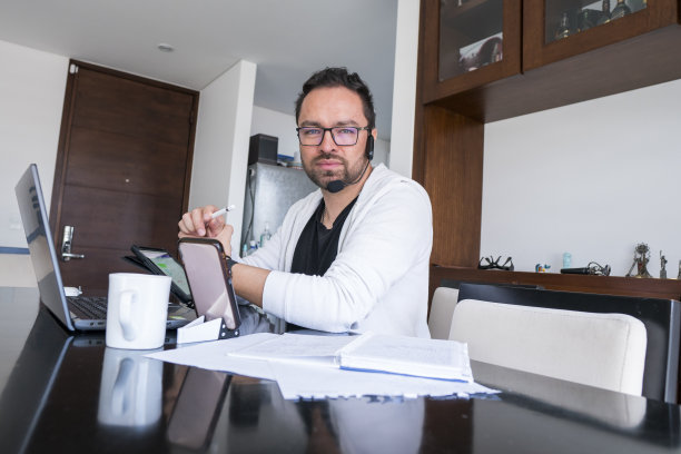 新冠肺炎隔离期间，一名男子在家中使用笔记本电脑工作图片下载