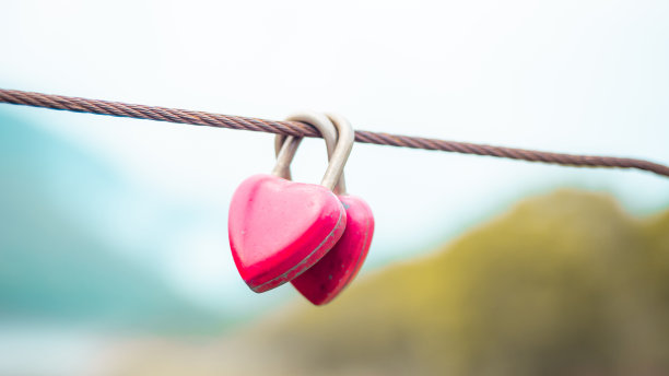 红色旧锁挂在电缆与模糊的自然背景。安全生活新常态理念。图片下载