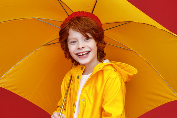 有趣的男孩在雨天带着伞图片下载