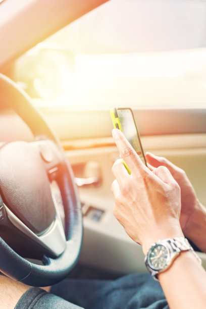 人们在车里拿着智能手机。图片下载