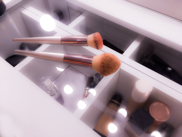 背景与配件和刷子，化妆梳妆台上方，白色和照明。图片下载