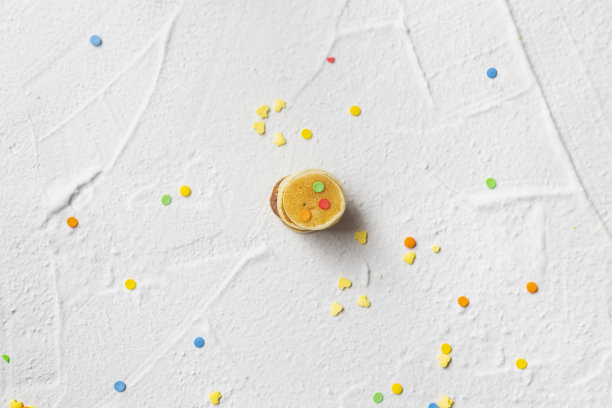 灰色纹理背景上的小煎饼和多色糖果。图片下载