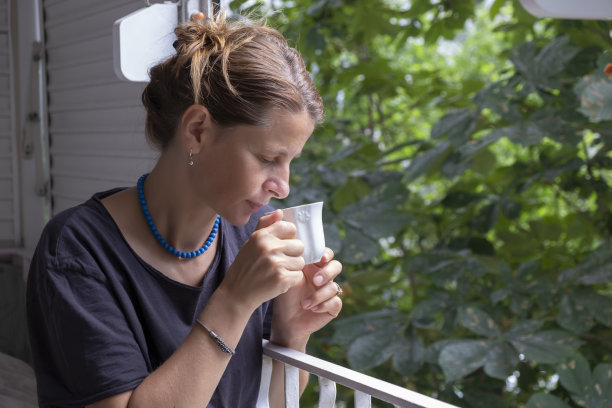 在阳台上喝着茶和咖啡的女人图片下载