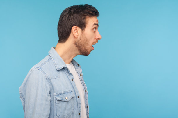 惊讶的人的侧面在工人斜纹棉布衬衫看一边拷贝空间在惊讶的张着嘴图片下载