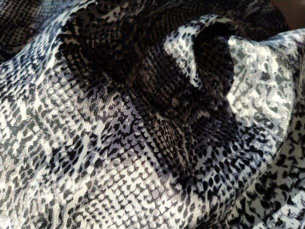 皱丝灰色斑点织物。织物的愉悦光泽，溢出的光反射在一块织物上图片下载