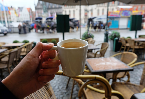 拿着陶瓷杯的热黑咖啡与视野图片下载