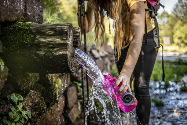 一位女登山运动员正在一股清新的山泉旁休息图片下载