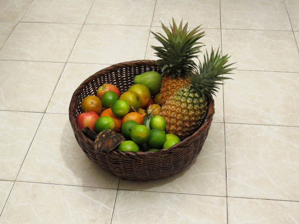 铺着瓷砖的地板上放着热带水果篮。图片下载