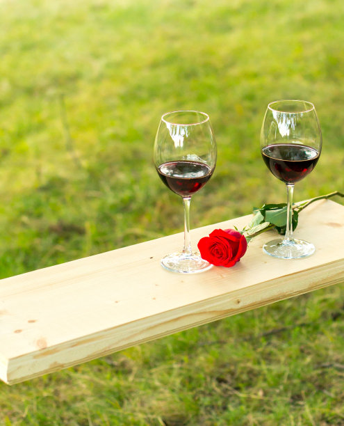 两杯红酒和红玫瑰。葡萄酒爱好者。图片下载