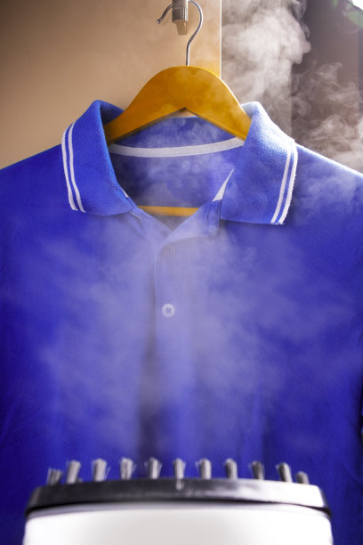 用熨斗烫衣服。裤子和网球衫。图片下载