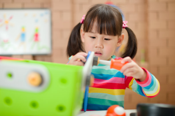 年轻女孩玩创造性玩具积木在家上学图片下载