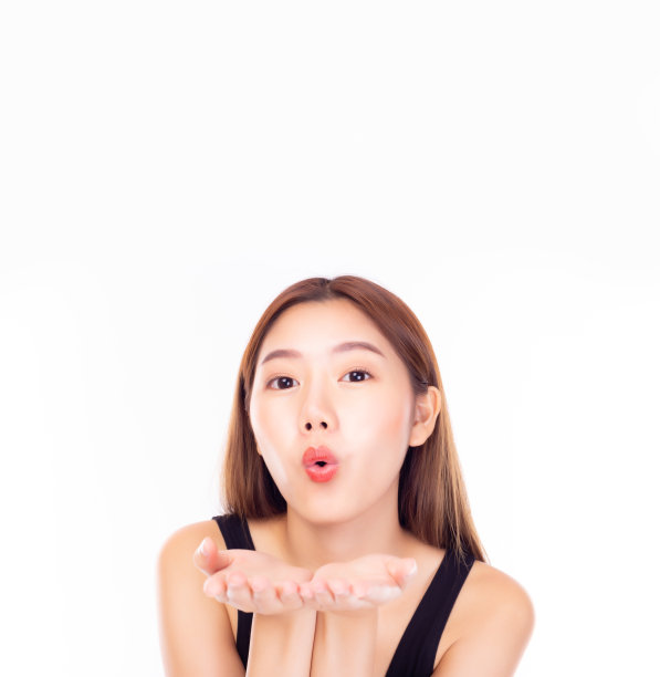 年轻漂亮的亚洲女性，在白色背景前飞吻，表达美好祝愿图片下载