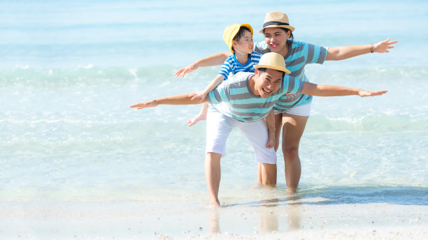 快乐的亚洲家庭，在海滩上尽情飞翔，享受休闲和目的地。家庭人旅游旅游享受在夏季和假期。旅游和家庭概念图片下载