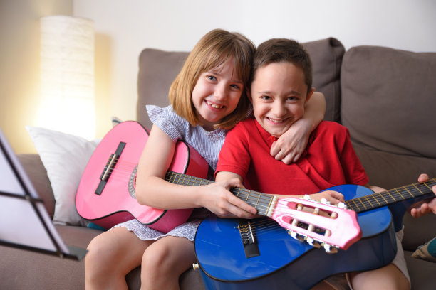 女孩和男孩练习吉他，在家里大笑图片下载