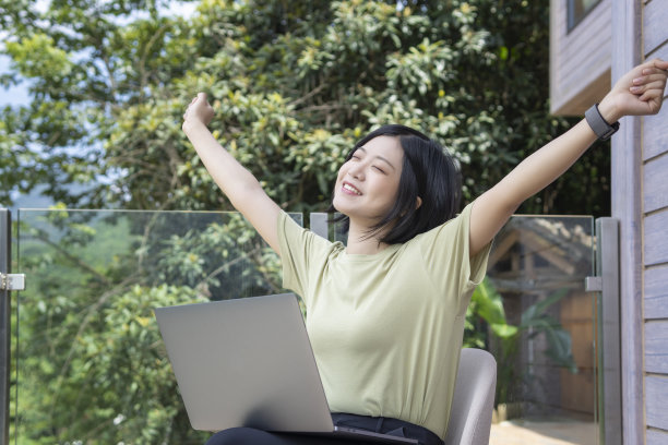 一位女性自由职业者在旅途中使用笔记本电脑在户外工作图片下载