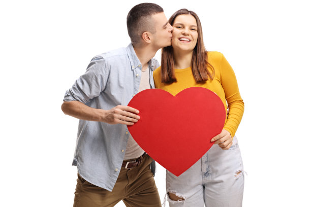 一名青年手持一颗红心亲吻一名女性图片下载