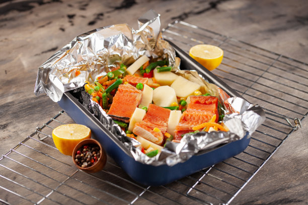 铝箔包晚餐。三文鱼和蔬菜箔。饮食的食物。图片下载