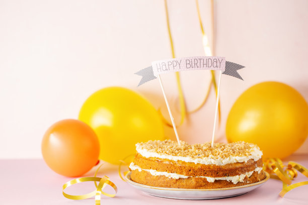 生日切蛋糕与武器生日快乐在粉红色的背景。图片下载