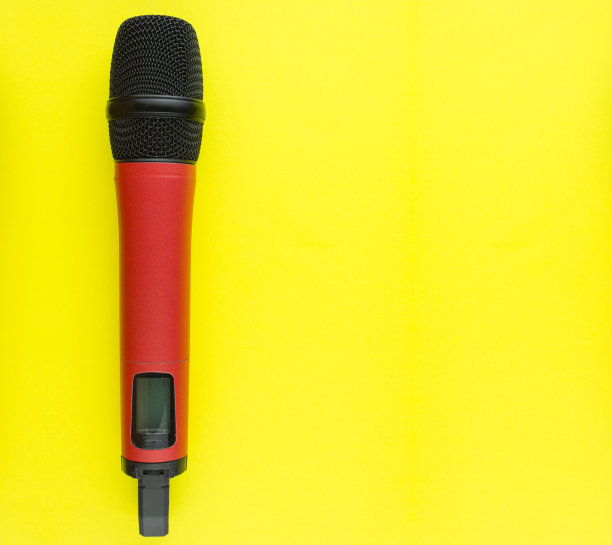 红色专业声乐无线麦克风，黄色背景。空间的文本。图片下载
