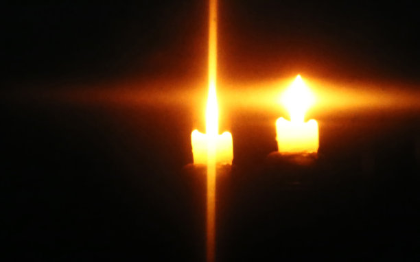 燃烧着的蜡烛的光束在一个十字架上图片下载